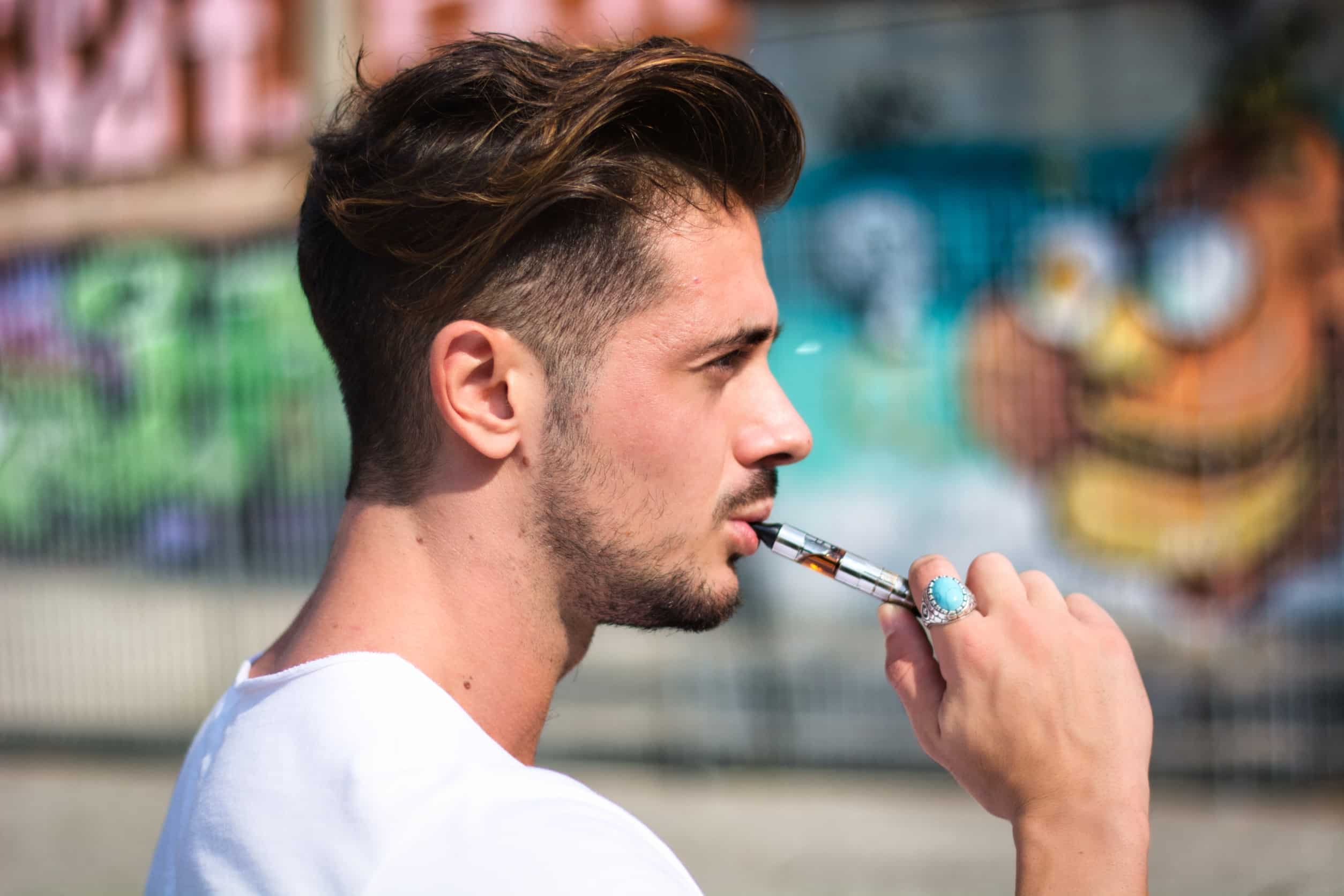 Homme fumant une cigarette électronique