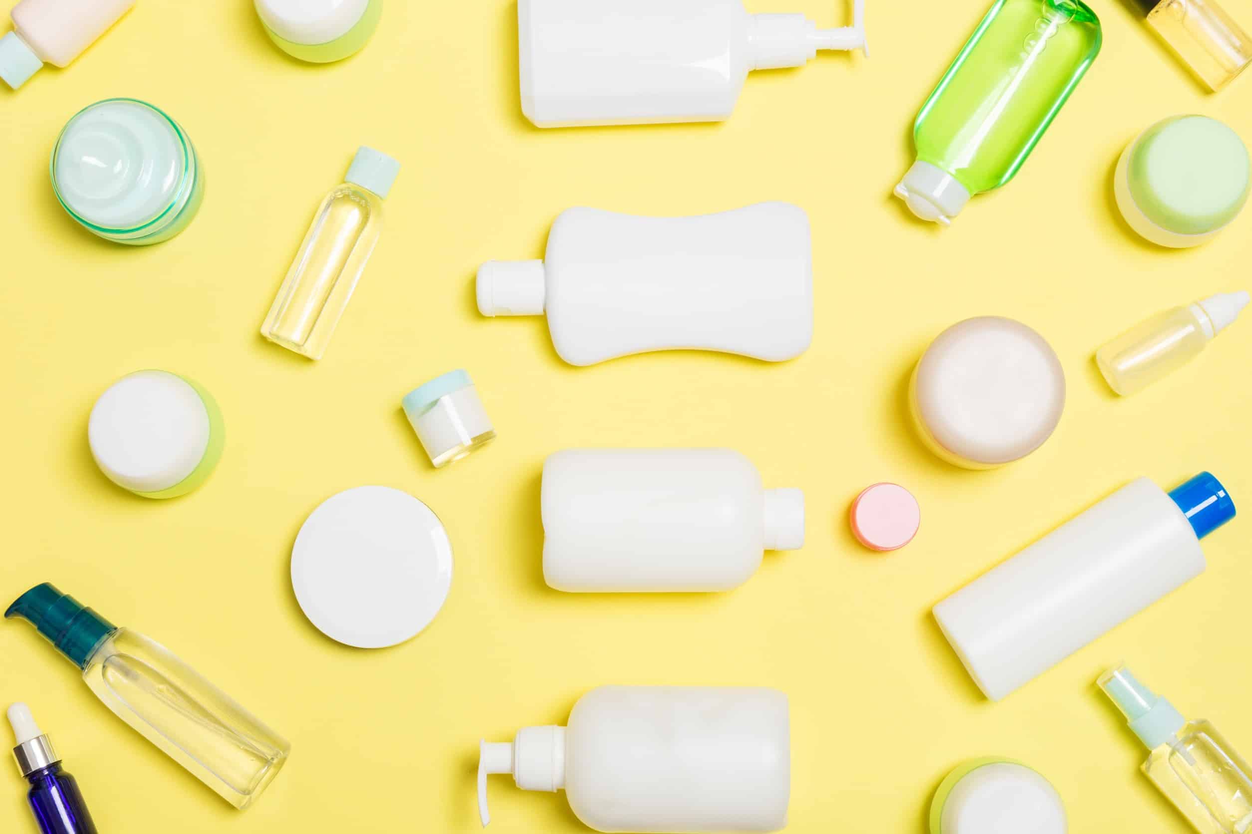 Groupe de bouteilles de soins corporels en plastique composition plate avec des produits cosmétiques