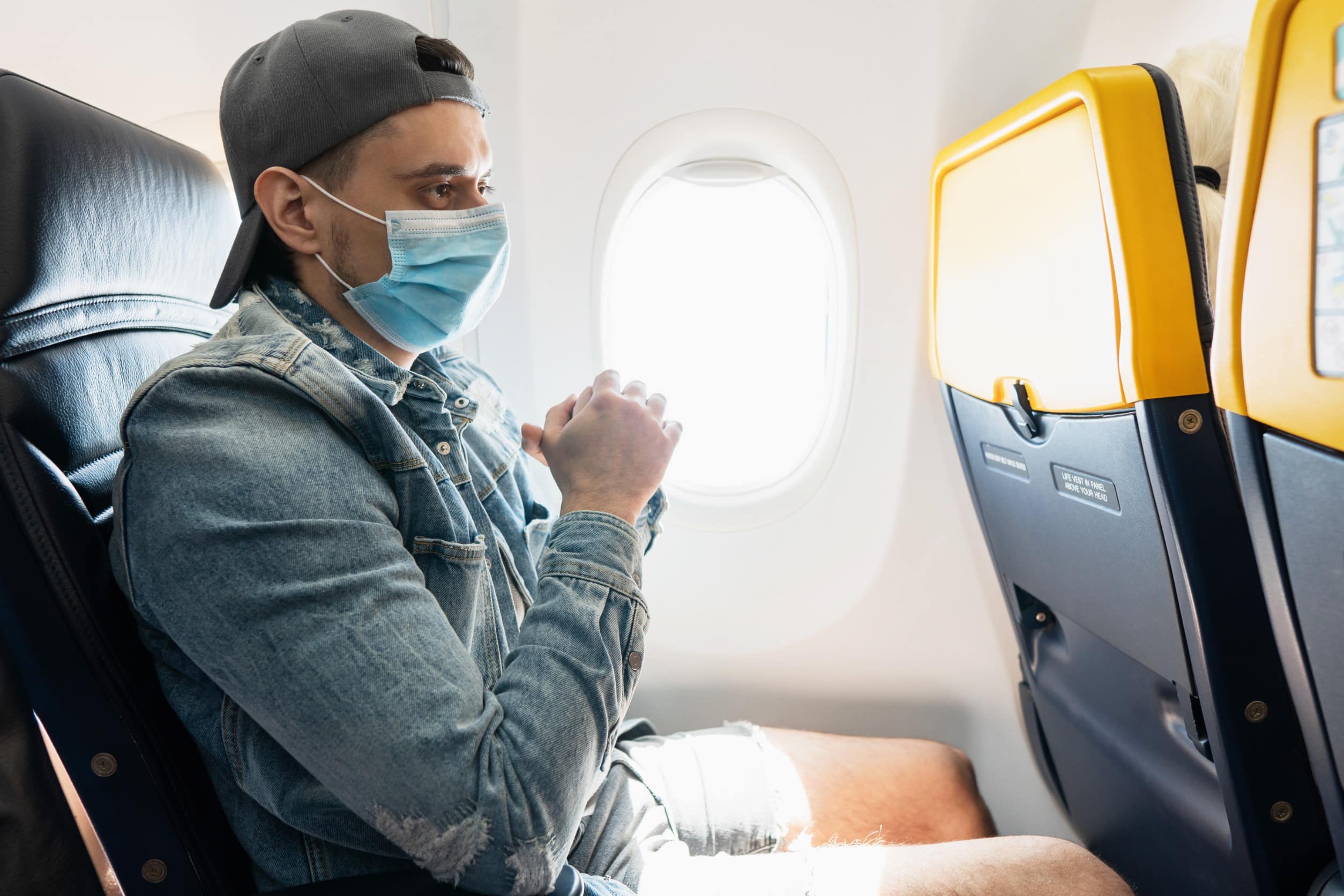 Homme portant un masque de prévention lors d'un vol à l'intérieur d'un avion